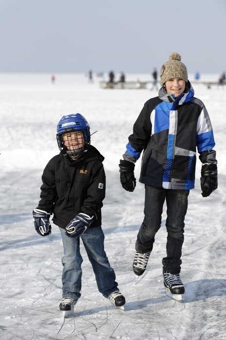 Parents and children ice skating Boys ice skating, playing ice hockey, St. Heinrich, Lake Starnberg, Five Lakes region, Upper Bavaria, Bavaria, Germany, Europe, Photo by Dr. Wilfried Bahnm ller