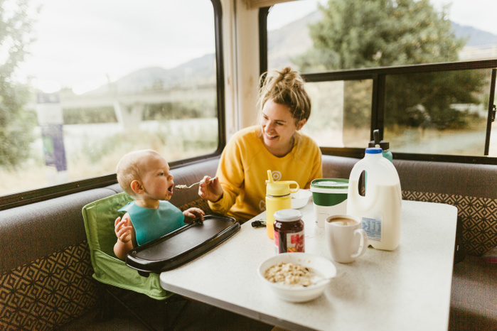 parent and child Mother feeding baby breakfast in motorhome