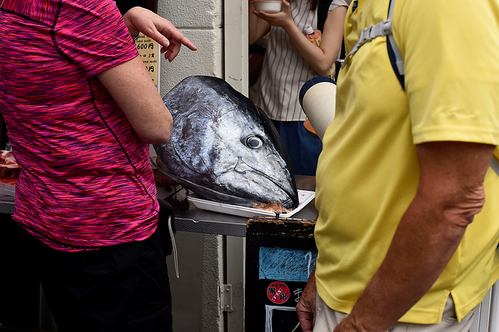 Tourists visiting Tsukuji Outer market September 5th 2019, Tokyo, Japan: Tourists watch a head of a tuna within the Tsukiji Outer market in Tokyo on September 5th 2019. Once the largest wholesale fish and seafood market in the world, the Tsukiji fish market has always been a popular tourist destination within the Tokyo area, with tourists flying in from all over the world to enjoy the shops and the tuna auctions. Even if the fish market has been moved to its new location in Toyosu on October 2018, Tsukiji Outer market still hold its place in the to do lists of tourists visiting Tokyo thanks to its authenticity and its fresh products.  Photo by Marie Froger AFLO 