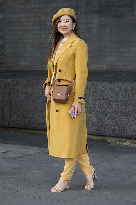 Spring Summer 2020 London Street Snapshot Street Style on day two of London Fashion Week SS 2020 on Friday September 13th 2019, showcasing stylish individuals London is internationally known for. Image shows Trisha Chen from Yew York. She wears a beret from ASOS, a coat from Pissenlit and bag from Jeff Wan , both NY designers, and high heel sandals by Stuart Weitzman. 