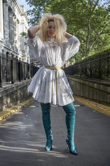 Spring Summer 2020 London Street Snapshot Street Style on day three of London Fashion Week SS 2020 on Saturday September 14th 2019, showcasing stylish individuals London is internationally known for. Image shows Angel from Manchester. She wears over the knee boots by Elisabetta Franchi, a white lace dress by Three People, a Vivienne Westwood necklace and a yellow Burberry belt