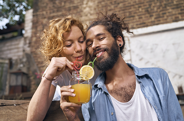 Young couple drinking cool lemonade in a backyard
