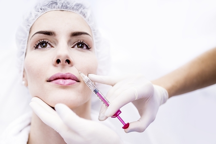 Woman injecting botox injection on face Young woman having a plasma and hyaluronic acid injection in her face to rejuvenate and smooth skin, close up.