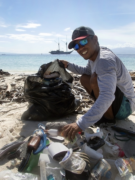 Collecting plastic waste on a beach, Indonesia Collecting plastic waste. The crew of an eco friendly cruise ship collecting plastic waste on a beach in Indonesia.