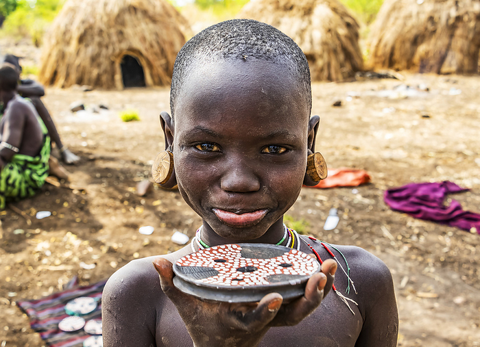 Mursi boy showing a lip plate in a village in Mago National Park; Omo Valley, Ethiopia, Photo by Peter Langer