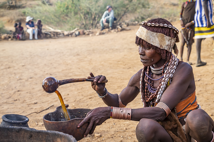 Hamer woman preparing a ceremonial drink at a bull jumping ceremony, which initiates a boy into manhood, in the village of Asile, Omo Valley; Southern Nations Nationalities and Peoples' Region, Ethiopia, Photo by Peter Langer