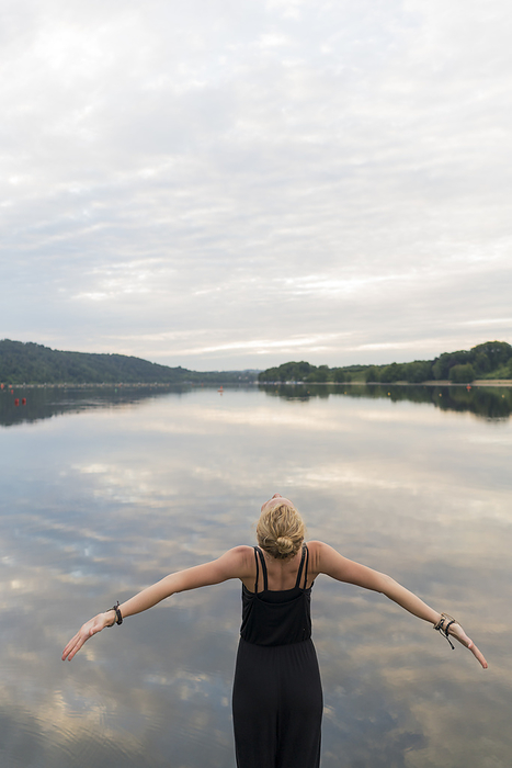 Young woman at a lake woth outstretched arms Young woman at a lake woth outstretched arms