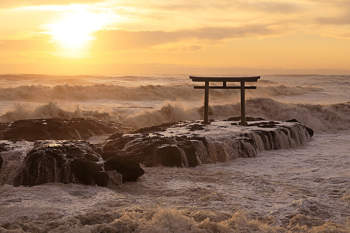 The Shinto shrine gate and sunrise on a stormy sea
