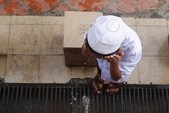 Nurunnaim mosque.  Ritual purity in Islam. Muslim boy performing Wudu ( ablution ).  Phnom Penh. Cambodia. 