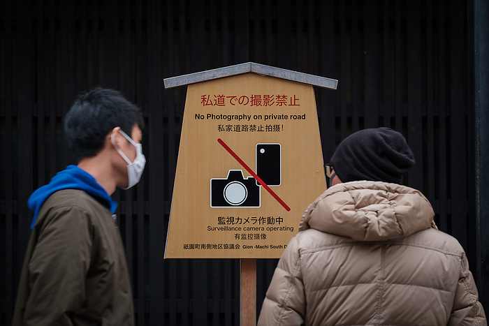 Kyoto, Coronavirus hit tourism business Men wearing a mask pass by a board sign banning photography on Hanamikoji Street on February 10, 2020. The boorish behavior of tourists who have harassed geisha, destroyed property and committed other obnoxious acts has led to a ban on photography on private roads in Kyoto s famed Gion district.Following the outbreak of Coronavirus situation many chinese tourists cancelled trip in Japan during winter. The city is empty of bus and tourist s groups. February 10, 2020  Photo by Nicolas Datiche AFLO   JAPAN 