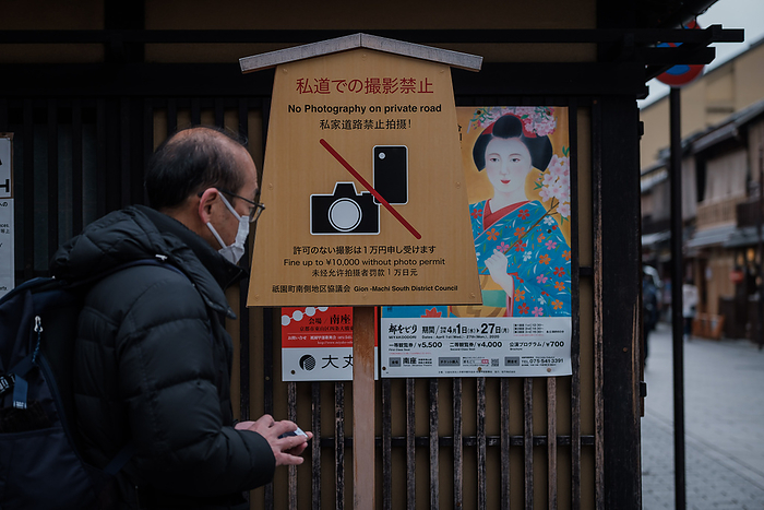 Kyoto, Coronavirus hit tourism business A man wearing a mask passes by a board sign banning photography and poster of geisha on Hanamikoji Street on February 10, 2020. The boorish behavior of tourists who have harassed geisha, destroyed property and committed other obnoxious acts has led to a ban on photography on private roads in Kyoto s famed Gion district.Following the outbreak of Coronavirus situation many chinese tourists cancelled trip in Japan during winter. The city is empty of bus and tourist s groups. February 10, 2020  Photo by Nicolas Datiche AFLO   JAPAN 