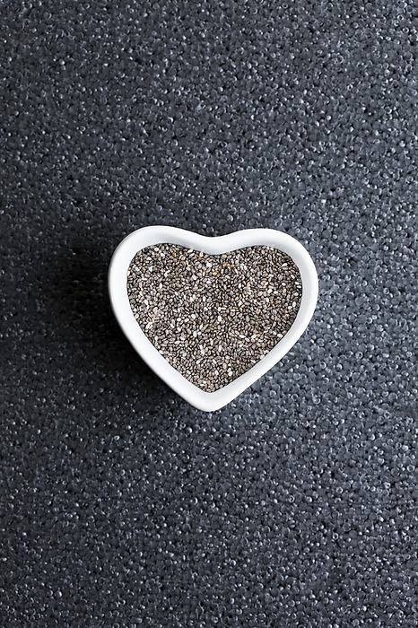 Black chia seeds in heart shaped dish Black chia seeds in heart shaped dish. Pile of chia seeds  Salvia hispanica . Chia is grown for its edible seeds, which are rich in omega 3 fatty acids and are traditionally eaten in Mexico, and the southwest of the United States.