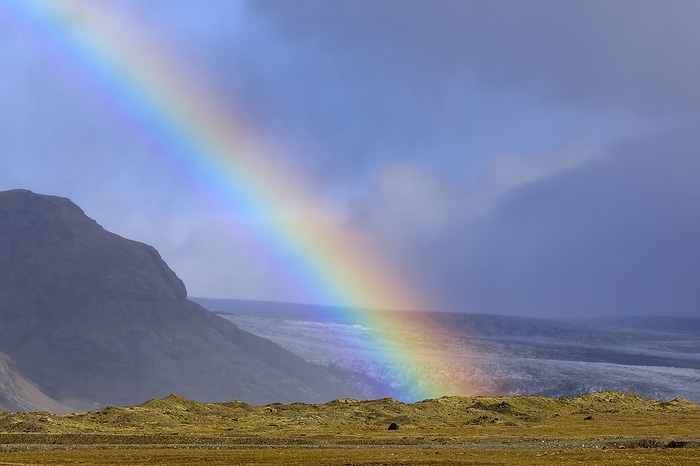 Rainbow over Icelandic glacier End of a rainbow over Breidamerkurjokull, a large outlet glacier from the Vatnajokull icecap in southeastern Iceland. The hills in the foreground are a terminal moraine left behind after Breidamerkurjoekull s recession after the Little Ice Age.