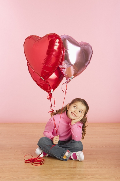 Valentine s Day a girl holding heart shaped balloons