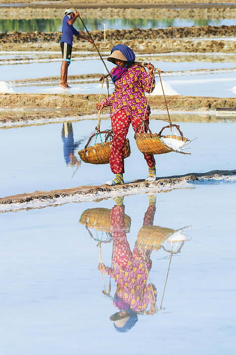 Woman with shoulder pole harvesting the salt fields around the Praek Tuek Chhu River estuary south of the city, Kampot, Cambodia Woman with shoulder pole harvesting the salt fields around the Praek Tuek Chhu River estuary south of the city, Kampot, Cambodia, Indochina, Southeast Asia, Asia, Photo by Robert Francis
