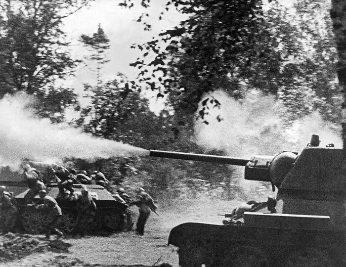 Moscow, Russia:   March 27, 1943.
A Russian tank blasts away with covering fire, while Red Army soldiers pour out of a troop carrier  to attack German positions.