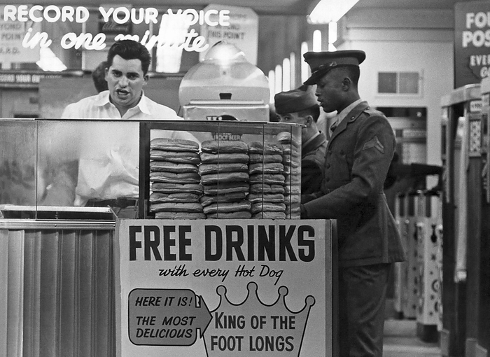 San Francisco, California  c. 1950.
The vendor at  the foot-long hot dog stand at Playland At The Beach in San Francisco. An African American soldier stands in line.
