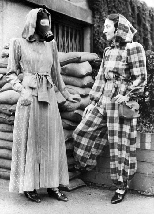 London, England:  Sept 14, 1939.
The very latest fashion in air raid shelter wear is a slip on dressing gown complete with hood, and can be left open, (left), or zipped into trousers, (right).