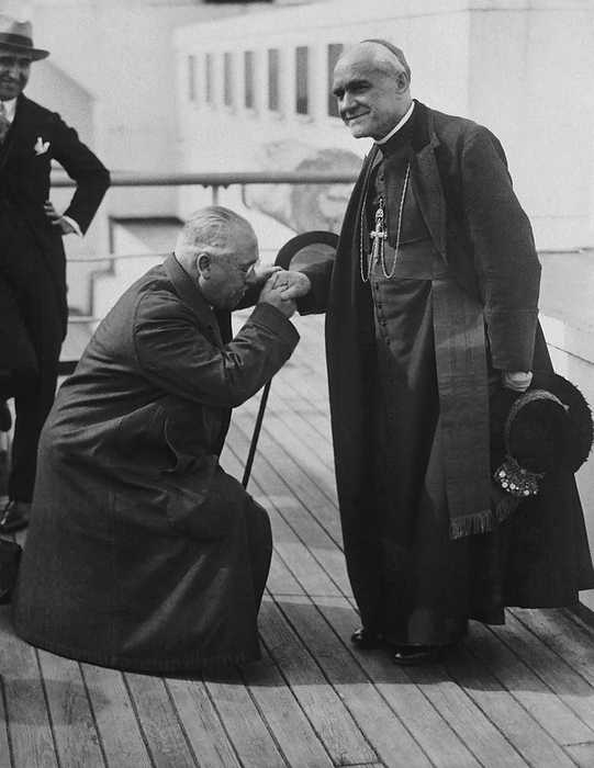 New York, New York:   June 11, 1926
Spanish Ambassador Del Riano on bended knee kissing the hand of Cardinal Reig y Casanova, Archbishop of Toledo, Spain who is here for the Eucharistic Congress in Chicago.