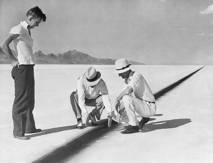 Bonneville Salt Flats, Utah:  September 1, 1935
AAA officials examine a portion of the 13 mile long jet black oil line that Sir Malcolm Campbell will follow in his attempt to set a new automobile speed record of 300 mph.