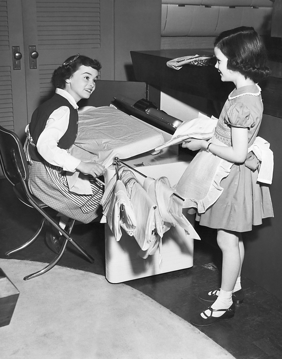 United States:  1951
Children doing ironing as they help out with the household chores.