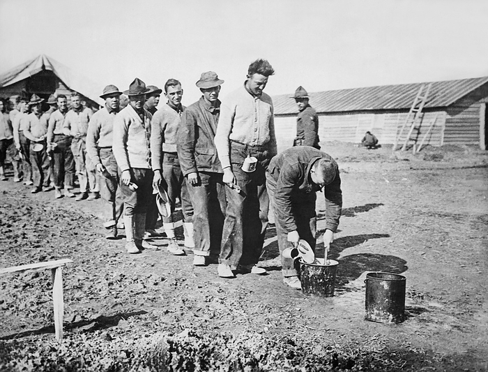 France:  December 16, 1917
American soldiers standing in line to clean their eating utensils in wash and rinse buckets after chow time.