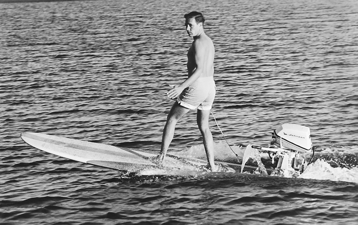 Dana Point, California:  c. 1960
Surfing champion and innovator Hobie Alter demonstrates the ultimate in surfboards with a 5 horsepower Johnson outboard motor attached to his surfboard.