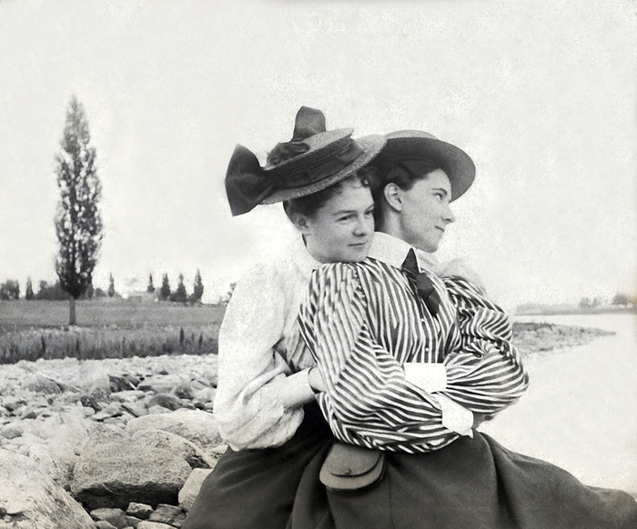United States:  1896
Two young Victorian women snuggle by a stream in the countryside.
