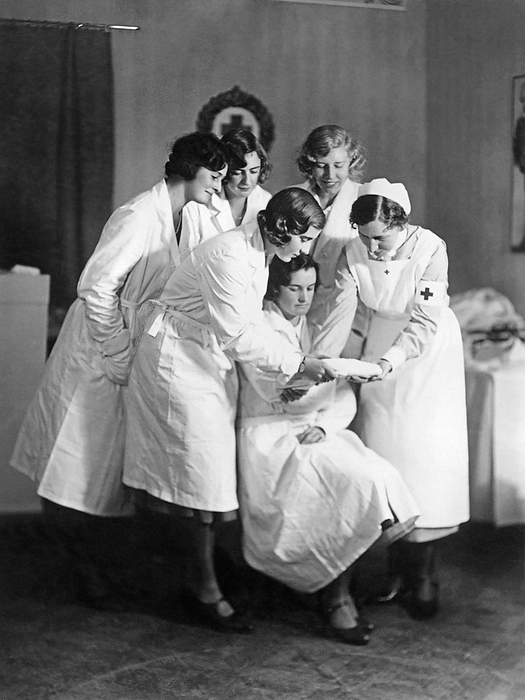 Stockholm, Sweden:  c. 1930
Princess Ingrid of Sweden (left in foreground) learning how to apply a compress to a patient as part of her course in nursing. She is the only daughter of Crown Prince Gustavus Aldolphus, son of KIng Gustav.