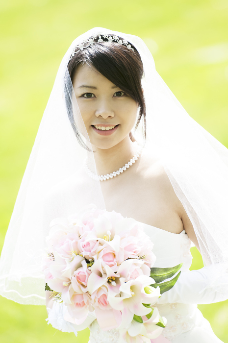 A smiling bride holding her bouquet