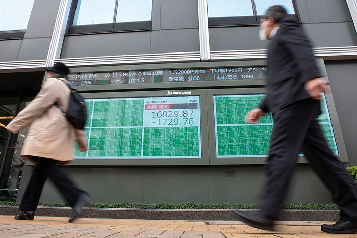 Tokyo stocks plunge following Wall Street crash People walk past an electronic stock board showing Japan s Nikkei Stock Average in Tokyo, Japan on March 13, 2020. Japanese stocks plunged more than 10  during the morning session on the Tokyo Stock Exchange market after Wall Street s biggest drop since the Black Monday crash of 1987.  Photo by AFLO 