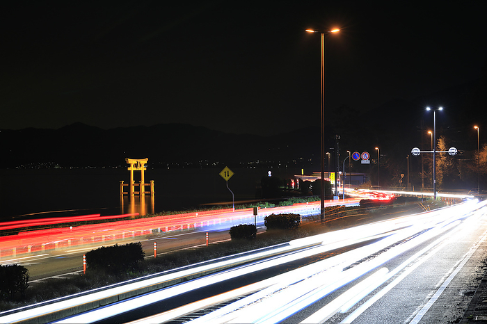 Shirahige Shrine, Shiga Prefecture: Illuminated Great Torii Gate in the middle of the lake and the light trail of cars on Kosai Road
