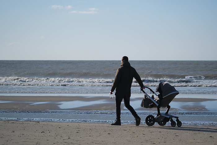 Outbreak of New Virus Pneumonia Worldwide, with a Series of Infections in Various Parts of Europe A father pulls a baby stroller as he takes a walk along the beach amid Coronavirus  COVID 19  pandemic on March 21, 2020 in Katwijk, Netherlands.  Photo by Yuriko Nakao AFLO   