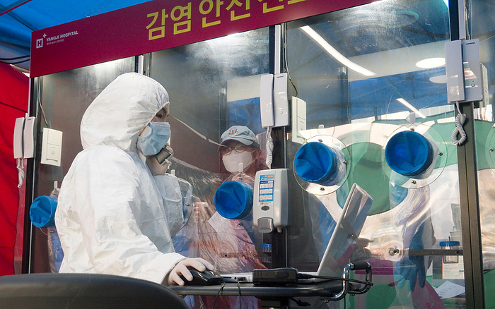 The world efforts to ride out the COVID 19 crisis Single person COVID 19 testing booth, Mar 18, 2020 : A doctor talks to a woman in a booth via intercom before the woman receives a COVID 19 test swab at a single person testing facility outside a hospital in Seoul, South Korea. The H plus Yangji Hospital set up public telephone booth style COVID 19 testing facilities in which medical team safely takes a swab from the patient inside the booth by use of gloves equipped on the booth and communicate with the patient by intercom. The single person booth to test for novel coronavirus enables medical team to avoid being exposed directly to patients and it reduces time for disinfection. South Korean government restricted religious gatherings, indoor sports activities and visits to nightclubs and other entertainment venues to slow the new coronavirus pandemic that emerged in China late last year.  Photo by Lee Jae Won AFLO   SOUTH KOREA 