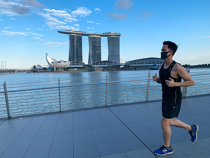 Singapore tightens face mask regulations to fight coronavirus A runner wears a face mask jogging in Marina Bay in Singapore on 15 April 2020. As of April 14th it is now mandatory to wear a face mask when outside the house except during strenuous exercise or for babies under two years old. First time offenders will be fined SGD300 and repeat offenders are liable for higher fines or prosecution. The new regulation was introduced to help combat the COVID 19 novel coronavirus.  Photo by Haruhiko Otsuka AFLO 