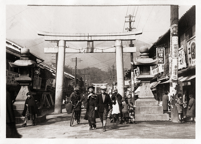 160902 0014   Ikuta Jinja Torii Stone lanterns and a scared torii gate at the entrance way to Ikuta Jinja, a Shinto shrine in Kobe, Hyogo Prefecture, ca 1932  Showa 7 .  Lots of shops line the street. The shrine is among the oldest shrines in Japan and is mentioned in the Nihon Shoki, the second oldest book of classical Japanese history.  The Battle of Ichi no Tani  1184  took place in and around Ikuta Shrine.  Photo by MeijiShowa AFLO