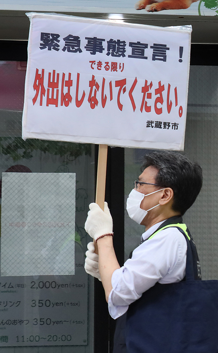 Musashino city officers hold a banner to demand to refrain from going out May 3, 2020, Tokyo, Japan   A Musashino city officer holds a placard to demand to refrain from going out at a shopping arcade in Tokyo on Sunday, May 3, 2020. Prime Minister Shinzo Abe is expecting to extend a state of emergency until end of this month.    Photo by Yoshio Tsunoda AFLO 
