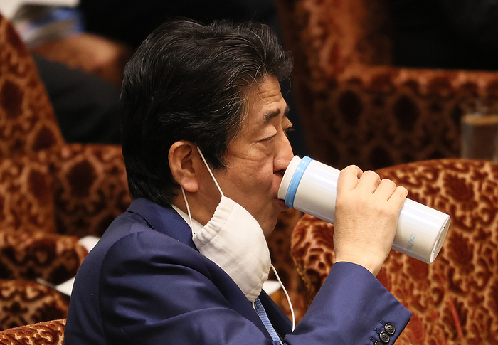 Japanese Prime Minister Shinzo Abe attends Upper House s budget committee session May 11, 2020, Tokyo, Japan   Japanese Prime Minister Shinzo Abe hanging a face mask from his ear drinks water at Upper House s budget committee session at the National Diet in Tokyo on Monday, May 11, 2020. The government is expecting to remove a state of emergency at some prefectures in Japan on May 14.    Photo by Yoshio Tsunoda AFLO 