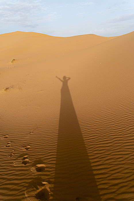 Sahara Desert, Morocco. Group of young woman travelling together. Explore, travel, adventure, holidays, Merzouga, desert, Sahara, dunes Shadow of a woman on sand dunes in Sahara Desert, Merzouga, Morocco