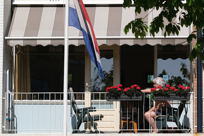 Netherlands Businesses Reopen As Lockdown Further Eased An elderly person sits outside his balcony as the Dutch national flag flutters on May 21, 2020 in Katwijk, Netherlands.   Photo by Yuriko Nakao AFLO   