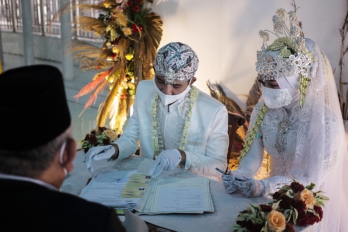 The Marriage ceremony amid concern COVID 19 in Indonesia A Groom and a bride wears face masks as a precaution, during their marriage ceremony in Bogor, Indonesia, June 6, 2020. The Marriage ceremony amid concern COVID 19, was held inside a home with least number of people, following of social distance and strict health protocol rule.