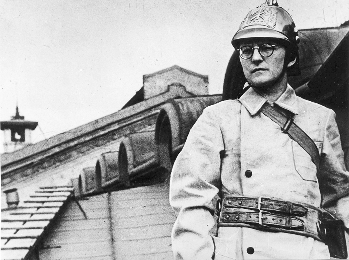  Musical Sages of the World Dmitrij Shostakovich  1941  Dmitri Shostakovich, Russian composer, during the Siege of Leningrad, USSR, WWII, 1941. Shostakovich  1906 1975  opted to remain in Leningrad when the German siege of the city began in September 1941, continuing work on his Seventh Symphony. He contributed to propaganda efforts, posing as a fire warden  pictured  and delivering a radio broadcast to the Soviet people. In October he and his family were evacuated to Kuybishev  Samara , where he completed the Seventh Symphony, which was adopted as a symbol of Russian resistance to the Nazi invasion. Found in the collection of the Russian State Film and Photo Archive, Krasnogorsk.