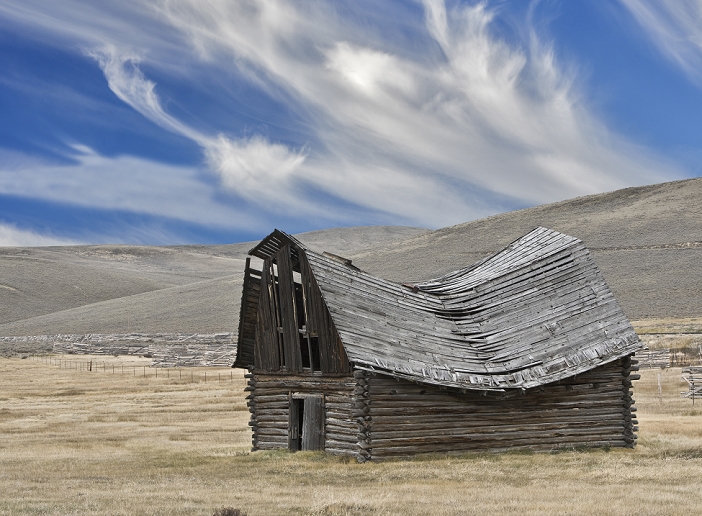 U.S.A., Montana, U.S.A., the piece of shit barn and the light clouds. Fallen down barn with wispy clouds. Montana