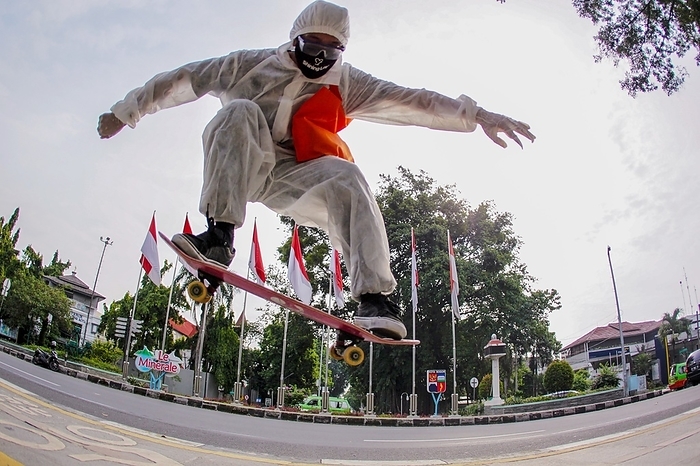 Playing skateboard during pandemic. A Skateboarder wearing a protective suit in action at a pedestrian on June 21, 2020 in Bogor, Indonesia. as the Indonesian government relaxes the coronavirus  COVID 19  restrictions.  