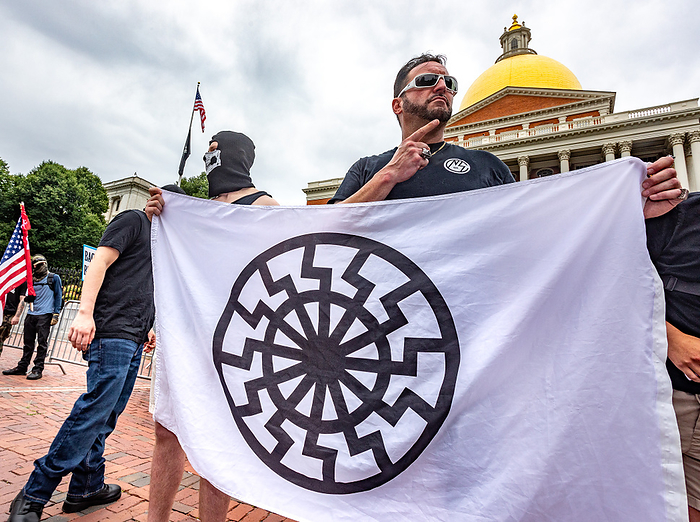 Police Supporters Demonstrate in Boston, U.S. Black Opposition Groups Also Gather in Protest June 27, 2020, Boston, Massachusetts, USA:Men wearing  Nationalist Social Club  shirt holds Black Sun flag  Schwarze Sonne  during a pro police rally outside the Statehouse in Boston.   Photo by Keiko Hiromi AFLO  