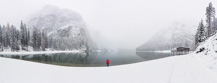Dolomites, Italy one person admires the splendid and famous Braies Lake undera a big snowfall, Natural Park Fanes Sennes braies, Dolomiti, municipality of Braies, Bolzano province, Trentino Alto Adige district, Italy, Europe., Photo by Carlo Conti