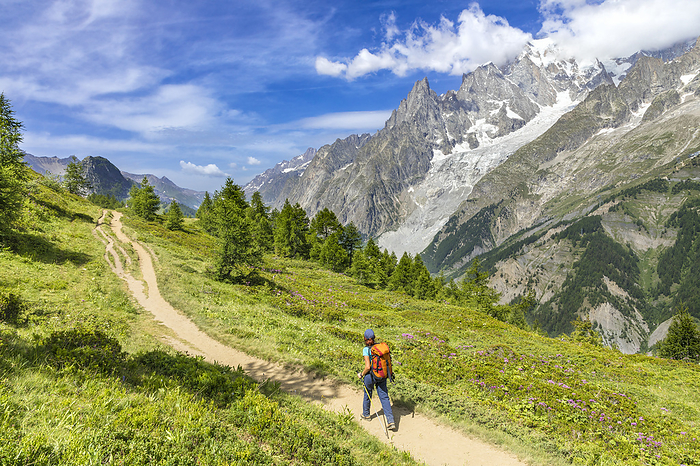 Italy View of the Mont Blanc Massif: a trekker is walking to the Bertone Refuge during the Mont Blanc hiking tours  Ferret Valley, Courmayeur, Aosta province, Aosta Valley, Italy, Europe   MR , Photo by Gabriele Prato