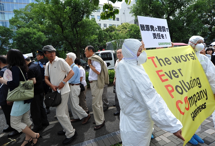 TEPCO Shareholders  Meeting Anti nuclear power plant demonstration outside the venue June 28, 2011, Tokyo, Japan   Amid ongoing protest against the operations of nuclear power plants, shareholders make their way to the general meeting of Tokyo Electric Power Co. in Tokyo on Tuesday, June 28, 2011.   It was the first time the operator of the crippled Fukushima No. 1 nuclear plant faces stockholders since the March 11 earthquake and tsunami that caused reactor meltdowns at the ill fated plant located some 210km northeast of Tokyo. The natural disaster and the nuclear catastrophe not only wiped about  36 billion off its market value but also displaced 50,000 residents because of radiation leaks.  Photo by Natsuki Sakai AFLO   3615   mis 