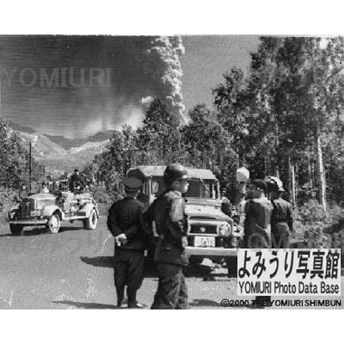Eruption of Mt. Tokachi, June 1962 Police and firefighting personnel take off limits measures. Eruption of Tokachi dake volcano. Police and firefighters take off limits measures. High plumes of smoke are rising behind the volcano. Six kilometers from Shirogane Hot Springs. Photo taken June 30, 1962, published July 1, 1962.