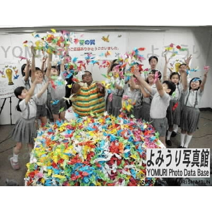 KONISHIKI and the children at the World Cup Soccer World Cup, showing 10,000 origami cranes soaring in the air. KONISHIKI  TV personality, center  and children from Sakamoto Elementary School in Chuo Ward, Tokyo, presenting the 10,000 origami cranes that will soar during the Soccer World Cup. Approximately 2.7 million origami cranes collected from elementary and junior high schools across Japan will land at the Yokohama International Stadium immediately after the World Cup finals.  At JAWOC in Yurakucho, Tokyo, June 24, 2002  Published in the morning edition of the 25th